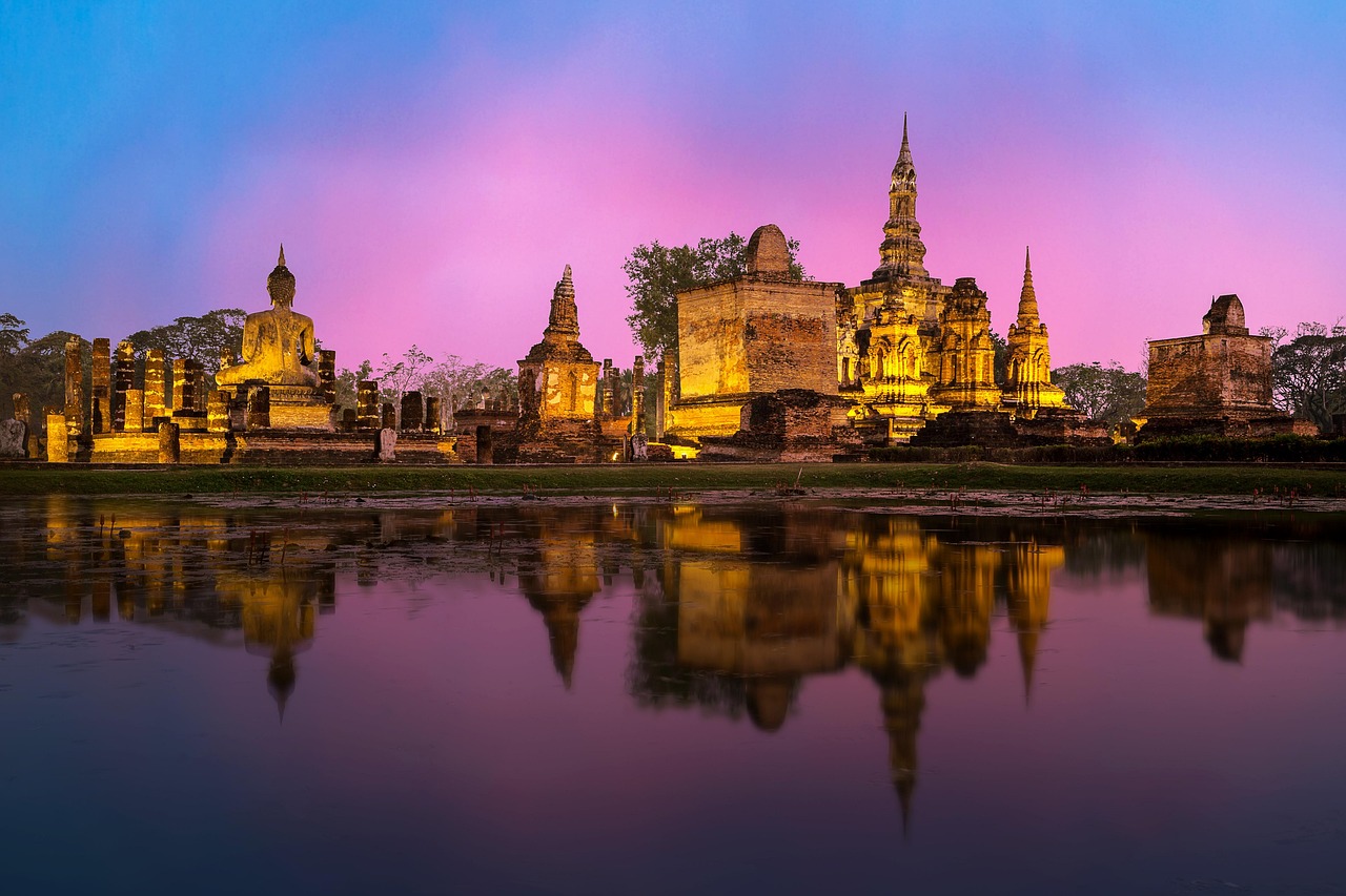 Thai temple at dusk across a lake with warm evening light