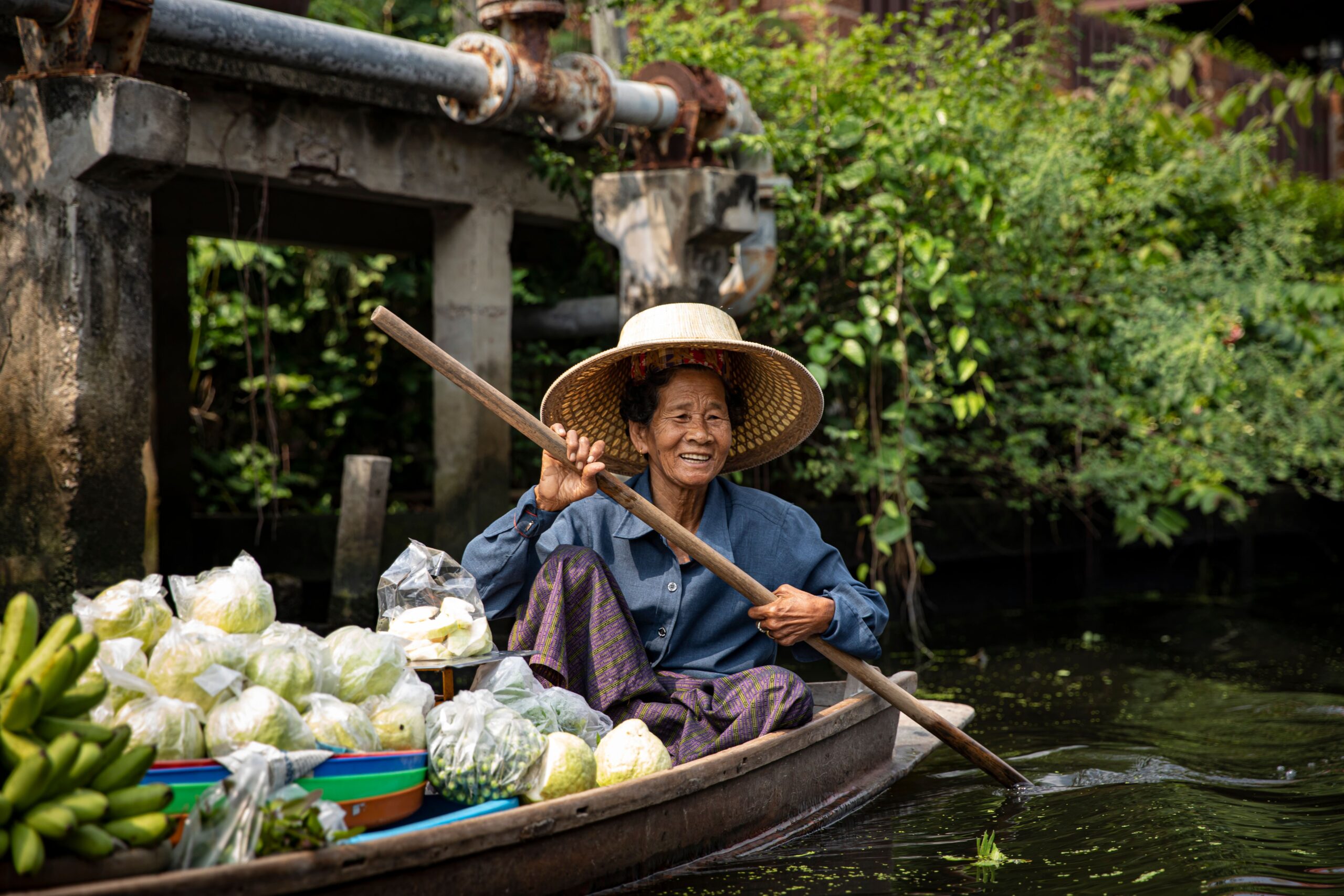 Thai woman in a canoe with vegetables representing local produce and tradition